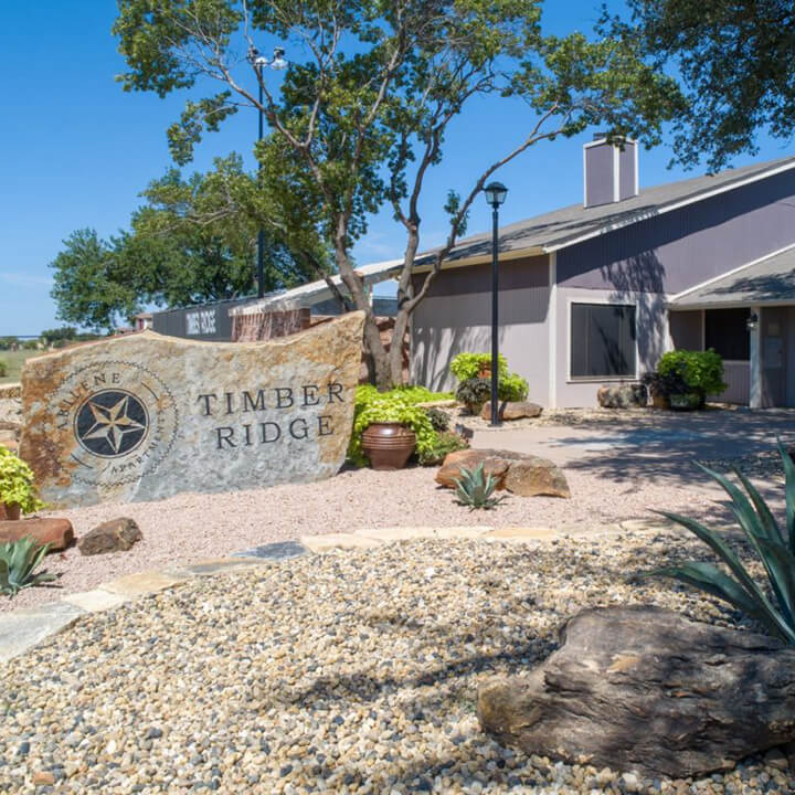 TRTX_Gallery_1 Sign outside of Timber Ridge Apartments in Abilene, TX with beautiful landscaping